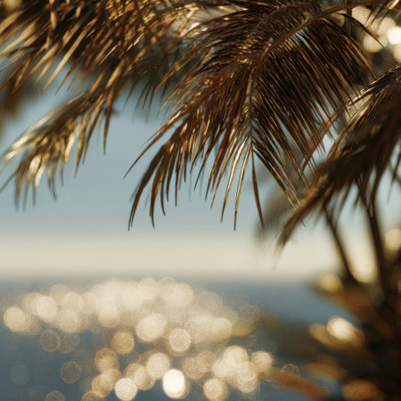 Captivating view of a sunset over the ocean, with palm leaves in silhouette. The shimmering light on the water creates a serene and tranquil atmosphere perfect for relaxation.の素材