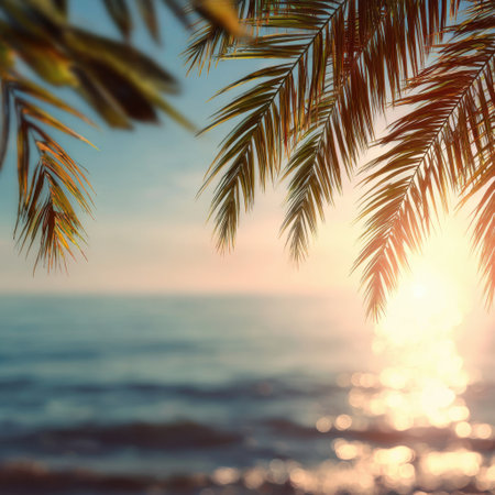 Captivating view of a serene sunset over the ocean, framed by vibrant palm leaves, creating a tranquil atmosphere perfect for relaxation and vacation vibes.の素材