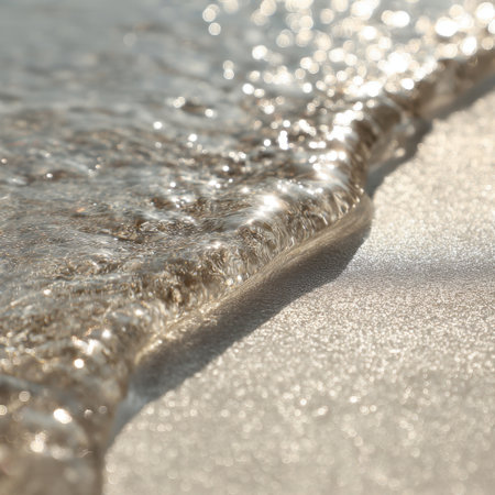 Gentle waves gently embrace a sandy beach under a bright sun, creating a serene and calming atmosphere perfect for relaxation and natural beauty.の素材