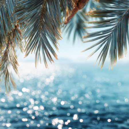 A serene view featuring lush palm tree leaves framing a sparkling ocean, showcasing the beauty of tropical nature under warm sunlight and inviting calm waters.の素材