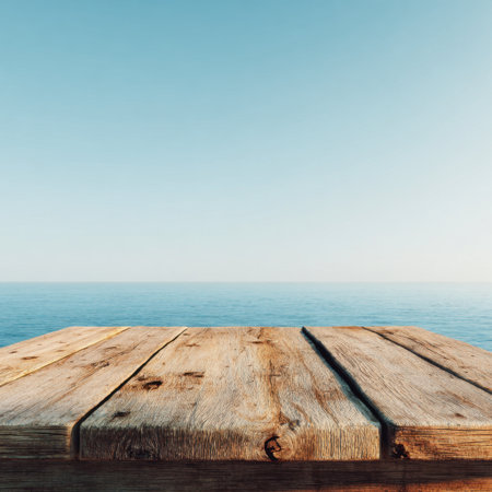 A stunning coastal scene featuring a weathered wooden table set against a tranquil ocean backdrop and clear blue sky, ideal for vacation and relaxation themes in photography.の素材