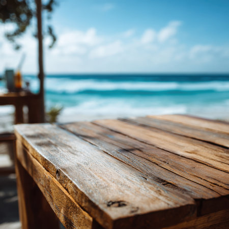 A beautiful seaside scene featuring a rustic wooden table with a stunning view of the ocean and waves, creating a perfect atmosphere for relaxation and summer enjoyment.の素材