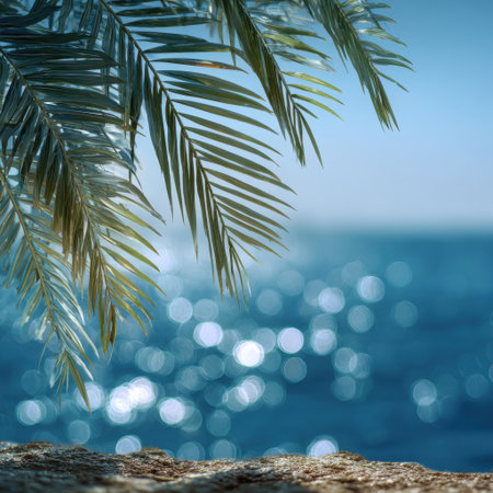 A stunning close-up of vibrant palm fronds with a bright blue ocean backdrop, creating a serene and tropical atmosphere ideal for vacation and relaxation themes.の素材