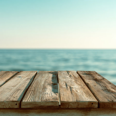 A peaceful seaside scene showcasing weathered wooden planks extending towards a calm ocean horizon, perfect for conveying tranquility and relaxation in photography projects.の素材