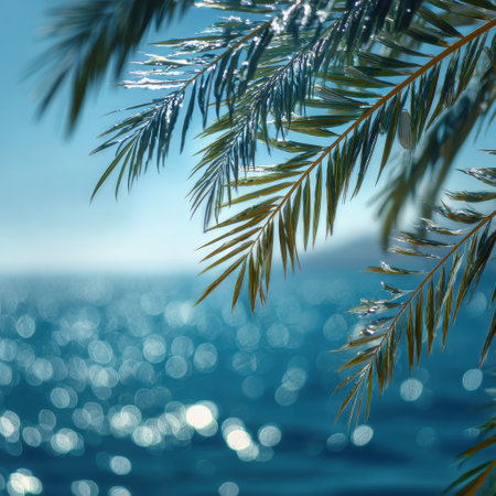 A captivating view of palm leaves against a serene ocean backdrop, showcasing soft sunlight reflections that create a perfectly tranquil atmosphere for relaxation and escape.の素材