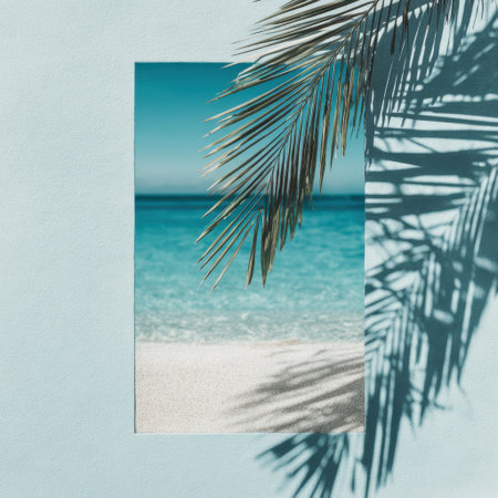 A beautiful beach scene showcasing clear blue water and palm fronds casting soft shadows on the sandy surface, evoking a sense of relaxation and summer tranquility.の素材