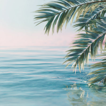 A tranquil beach scene captures palm leaves swaying gently above calm turquoise waters, with a soft pink sky at dawn creating an inviting atmosphere for relaxation.の素材