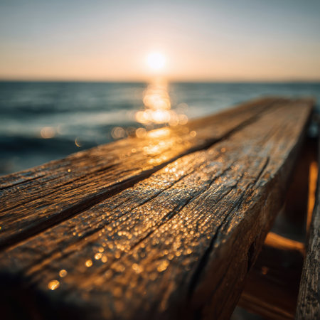 A captivating sunset over a tranquil ocean viewed from a weathered wooden dock, highlighting nature's beauty and providing a serene atmosphere for relaxation and reflection.の素材