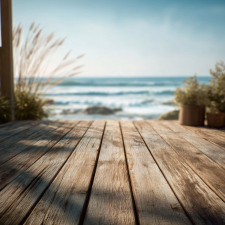 A tranquil scene depicting a weathered wooden deck overlooking the ocean, framed by greenery and waves gently lapping at the shore, evoking peace and relaxation.の素材