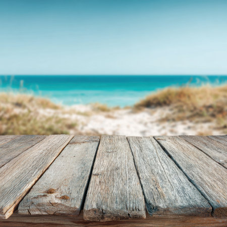 A serene beach scene featuring smooth wooden planks leading to gentle waves, capturing the essence of a peaceful coastal getaway under a clear sky.の素材