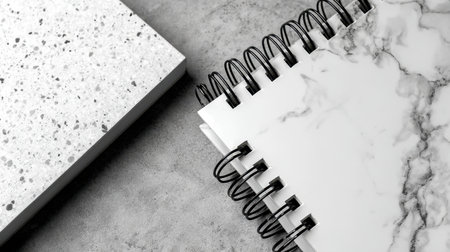 A contemporary flat lay featuring spiral notebooks against a textured stone background, showcasing a monochrome color scheme ideal for a modern workspace aesthetic and creativity.の素材