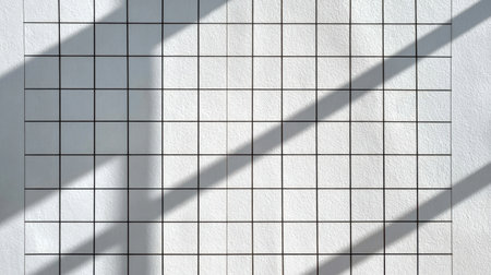 This image features a minimalist white wall adorned with a subtle grid pattern, showcasing elegant shadows cast by natural light, ideal for artistic and design projects.の素材