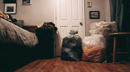 A cluttered bedroom showcases bags of trash, emphasizing the need for cleanliness and organization in everyday living spaces to promote a healthier environment.の素材