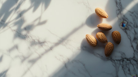 A captivating arrangement of almonds on a sleek marble surface creates an elegant visual with soft shadows, ideal for promoting healthy eating and culinary arts.の素材