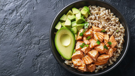 A fresh salmon bowl featuring tender slices of salmon, brown rice, and creamy avocado, arranged beautifully on a dark background. Ideal for meal prep and healthy eating.の素材