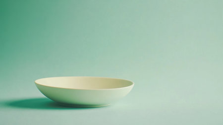 This image showcases a minimalist ceramic bowl placed on a soft pastel background, perfect for highlighting culinary creations or enhancing modern dining aesthetics.の素材