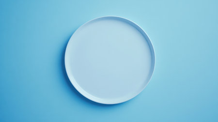 This image features a simple white plate set against a soft blue background, perfect for minimalist culinary presentations and modern table settings in food photography.の素材