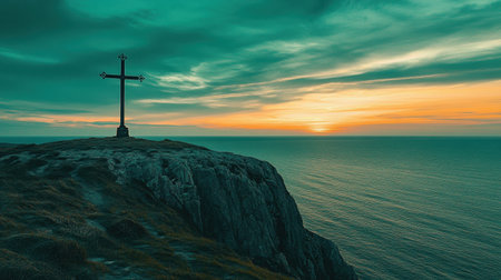 A stunning view of a cross standing tall on a rocky cliff, overlooking a calm sea at sunset, with dramatic clouds creating a serene and peaceful atmosphere.の素材