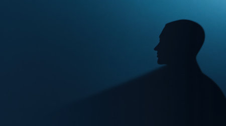 This captivating silhouette of a person against a dark backdrop showcases soft lighting that evokes mystery and contemplation, ideal for creative and artistic projects.の素材