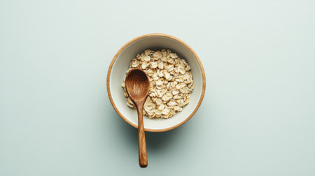 This image showcases a rustic bowl filled with oats, accompanied by a wooden spoon, highlighting the simplicity and beauty of natural breakfast ingredients.の素材