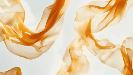 This image features flowing translucent fabric ribbons in warm amber shades, creating a captivating abstract background with a sense of gentle movement and light play.の素材