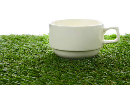 Ceramic cup on green fieldの写真素材