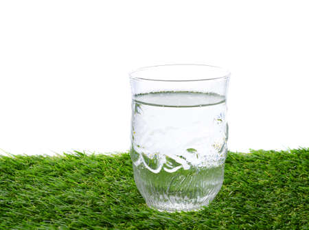glass of water on green fieldの写真素材