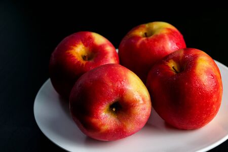 Chilled red apples Water droplets stick to the skin, sweet taste on a white dish, green.の写真素材