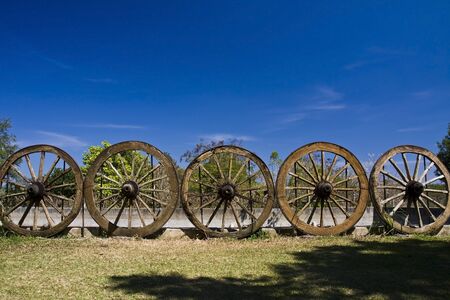 Old cartwheels on blue skyの写真素材