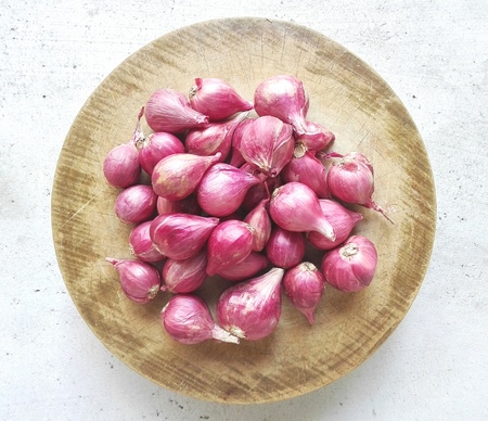 Shallots on wooden circular