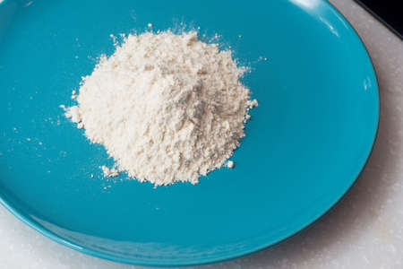 flour in the blue dish for cookingの写真素材
