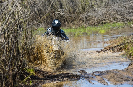 Khabarovsk , Russia - may 10, 2015 : Enduro motorcycle rides through the mud with a big splash at...