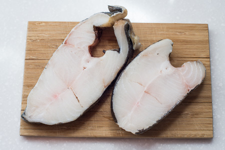 Halibut fish steak isolated on a white studio background.の写真素材