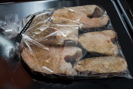 Raw white fish in black plastic box packaging. Copy space.の写真素材