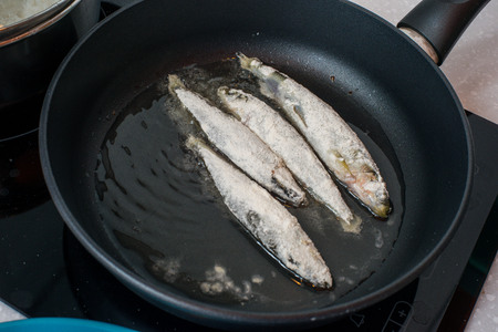 Fried small smelt tasty fish on a barbecue grill  hotplateの写真素材