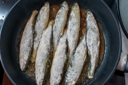 Fried small tasty fish on a barbecue grill  hotplateの写真素材