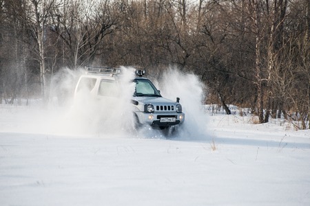 Khabarovsk, Russian - February 19, 2016 : car Suzuki Jimny rides through the snow on tracks in winterのeditorial素材