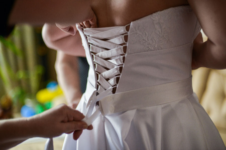 close up view of woman putting some shoe on shoes brideの写真素材