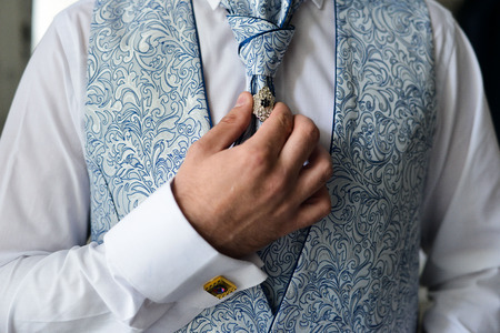 Close-up of a man in a tux fixing his cufflink. groom bow tie cufflinksの写真素材
