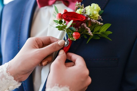 Close-up of a man in a tux fixing his cufflink. groom bow tie cufflinks