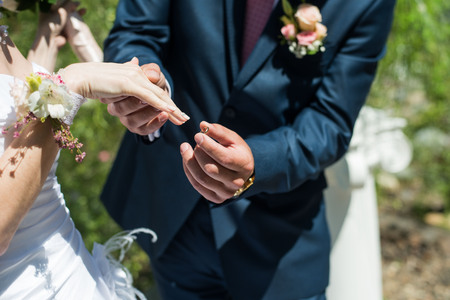 man wears wedding ring on the hand of the womanの写真素材