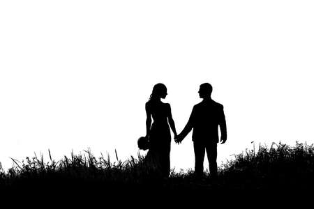 silhouette of bride and groom in the grass on a white backgroundの写真素材
