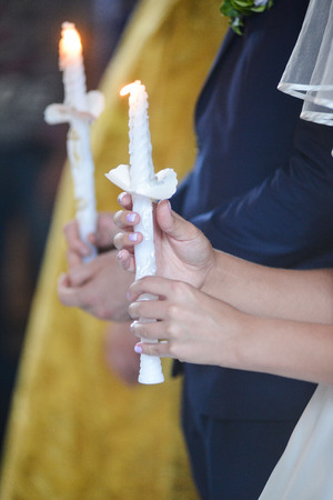 The groom and the bride with candles. Wedding ceremony in church candle wedding Churchの写真素材