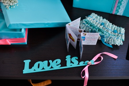 Garter on the leg of a bride, slim sexy bride in wedding luxury dress showing her silk garter with golden ribbon. woman have a final preparation for wedding ceremony. Wedding day momentsの写真素材