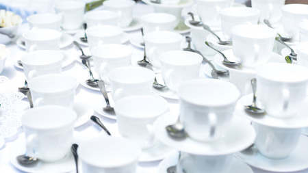 Table full of tea or coffee cups in line ready for a meeting refreshment break.の写真素材