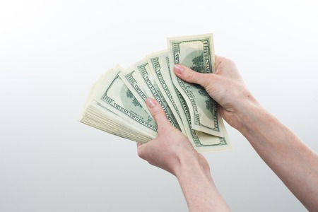 girl believes the dollars in hand on white backgroundの写真素材