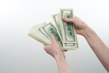 girl believes the dollars in hand on white backgroundの写真素材