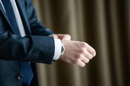 Close-up of a man in a tux fixing his cufflink. groom bow tie cufflinksの写真素材