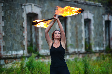 Fire show girl with flaming torchesの写真素材
