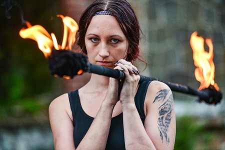 Fire show girl with flaming torches